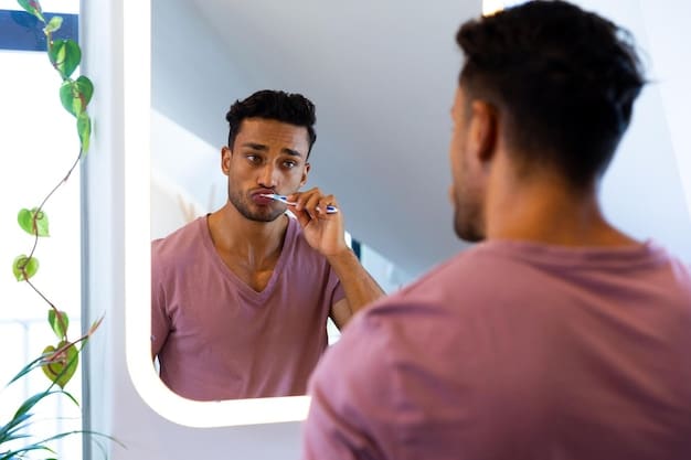 A man using a spoolie brush to comb his eyebrows upwards in front of a mirror, preparing to trim them with small scissors.