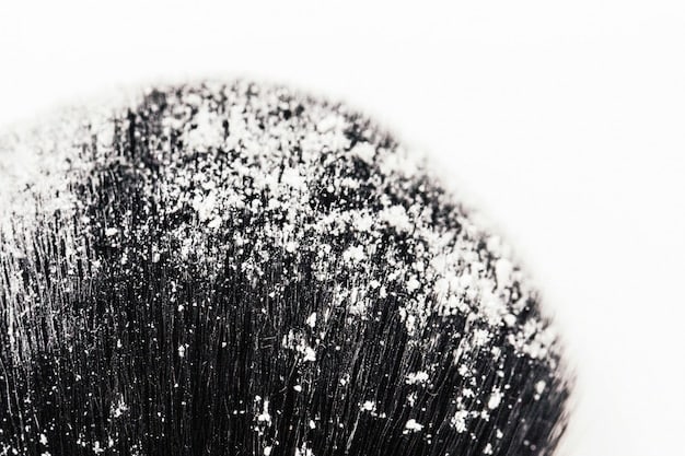 A side-by-side comparison of natural and synthetic makeup brush bristles under a microscope. The natural bristles show a scaly texture, while the synthetic bristles appear smooth and uniform.