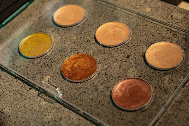 A close-up of different shades of bronzer powders displayed in a store, ranging from light tan to deep bronze, with a focus on matte and shimmer finishes.