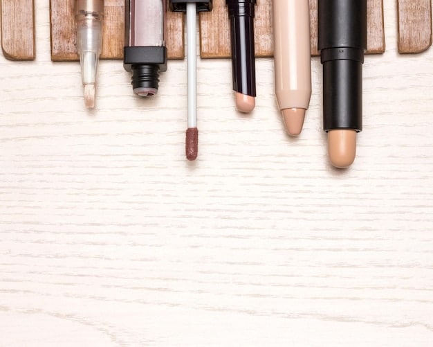 A selection of makeup products including concealer, tinted moisturizer, brow gel, and lip balm arranged neatly on a clean white surface. The lighting is bright and even, highlighting the textures and colors of the products.