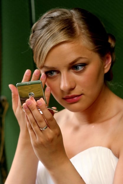 A close-up photo of a made-up man at a wedding. Focus on how well the makeup is applied - natural and sleek.