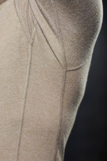 A close-up of various unisex athleisure pieces like joggers made from sustainable materials, a moisture-wicking t-shirt, and minimalist sneakers, showcasing the textures and design details of the clothing.