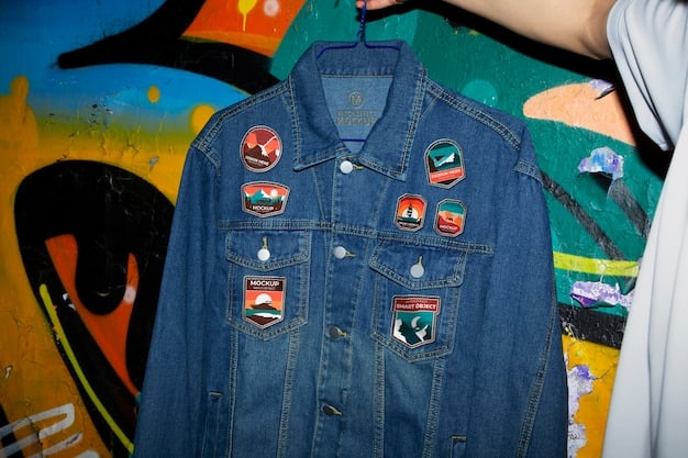 A close-up of a customizable unisex denim jacket adorned with various patches, pins, and embroidered designs. The patches feature diverse themes, including nature, music, and social justice. The jacket also has hand-painted elements, showcasing the owner's creativity and individuality.