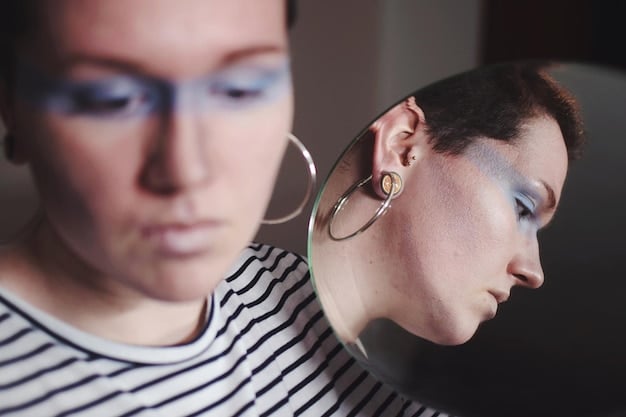 A person showcasing multiple ear piercings with an assortment of earrings, including hoops, studs, and dangling pieces. The focus is on the creative arrangement and the way different earring styles complement each other, highlighting the trend of personalized ear curation in non-binary style.