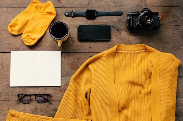 A close-up shot of various clothing items laid out on a table. Items include a crisp white button-down shirt, a pair of well-fitting dark wash jeans, a tailored grey blazer, and a pair of neutral-colored ankle boots. Fabric textures and stitching details are visible.