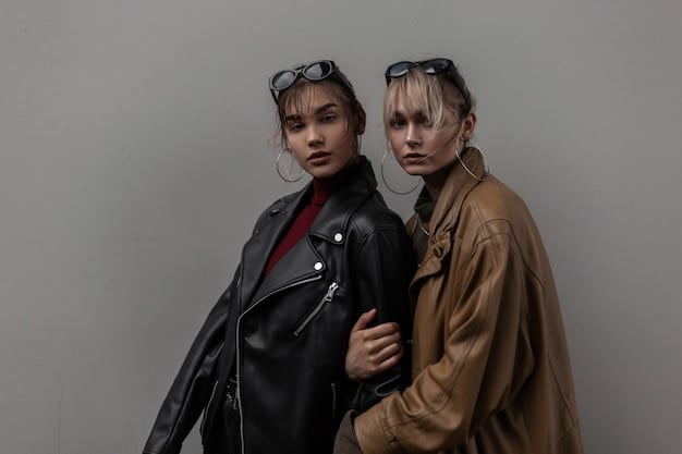 A model showcasing a non-binary outfit consisting of a designer leather jacket paired with a thrifted graphic tee, affordable high-waisted jeans, and high-end designer boots. accessories include both an expensive watch and some inexpensive bracelets.