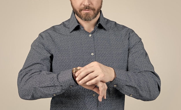 A close-up shot showcasing a person's hands adjusting the cuffs of an oversized button-down shirt. The focus is on the intricate details of rings on their fingers and the relaxed fit of the shirt, suggesting a casual yet stylish look.