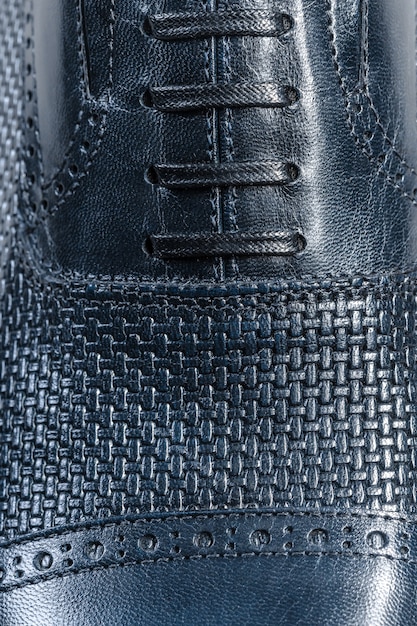 A close-up shot of a pair of black leather Oxfords, highlighting the intricate stitching and polished surface. The shoes are placed on a neutral-colored surface, emphasizing their classic and sophisticated design.