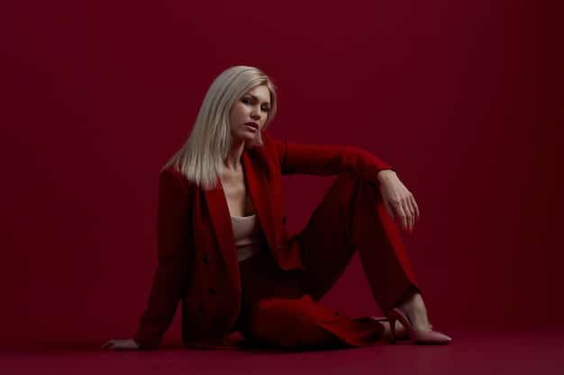 A recent photo of Tilda Swinton on a red carpet, wearing a sleek, minimalist androgynous outfit with sharp lines and a monochromatic color scheme.