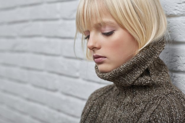 Close-up of a person with a pixie cut, styled with a slightly messy and textured look. They have a defined jawline and are wearing a simple, neutral-colored outfit.