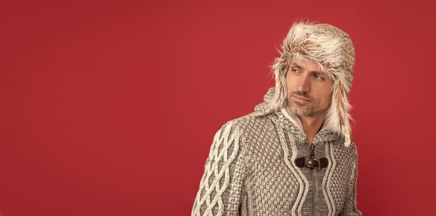 A person with a modern mullet haircut, styled with soft waves and texture. They have a relaxed expression and are wearing a vintage-inspired outfit.