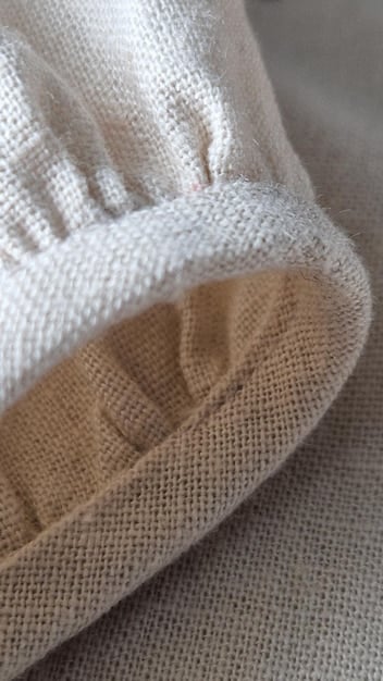 A close-up of various lightweight fabrics, including linen, cotton, and seersucker, showcasing their textures and breathability. Swatches are arranged to highlight their suitability for summer clothing.