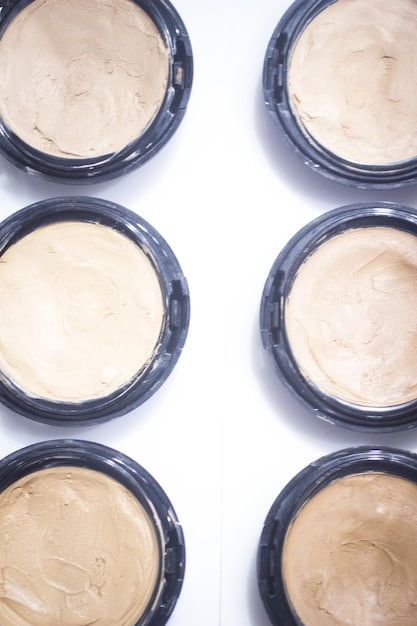 A close-up of four different foundation bottles – liquid, cream, powder and stick – each with a unique texture and consistency.