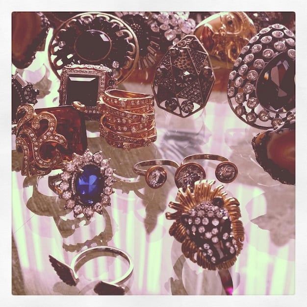 A close-up showcase of various statement jewelry pieces, including chunky necklaces, oversized rings, and bold earrings, arranged on a textured background to highlight their unique designs and styles.