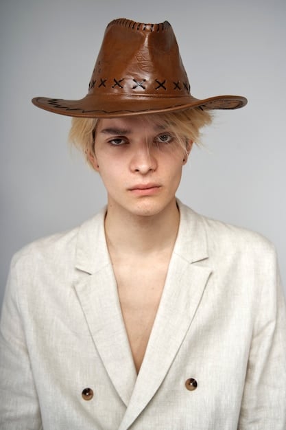 A person with a gender-neutral presentation wearing a variety of hats, including a classic fedora, a trendy baseball cap, and a cozy beanie, each paired with different unisex outfits to demonstrate their versatility.
