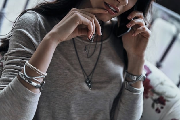 A person wearing a variety of gender-neutral accessories, including a minimalist necklace, a chunky ring, and a crossbody bag. The accessories are styled in a way that is both fashionable and functional.