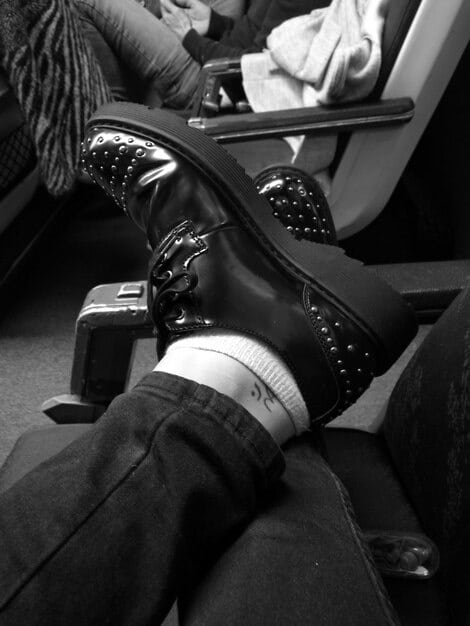 A stylish pair of gender-neutral chunky lace-up boots, set against a dark, textured background, highlighting their sturdy construction and fashion-forward design.