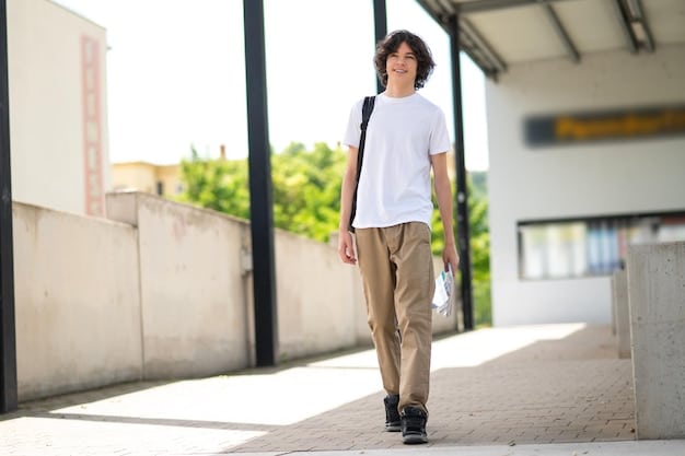 A person confidently walking in a street while wearing a crisp white unisex t-shirt tucked into high-waisted black tailored wide-leg trousers, layered with a charcoal grey oversized blazer and minimal gold jewelry, exuding a chic smart-casual vibe.