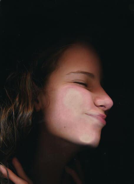 Close-up shot of a person's face, showcasing deconstructed contouring with subtle shading and highlighting. The background is a soft, diffused light.