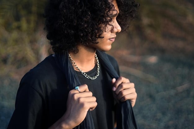 A person with short hair wearing several delicate necklaces of varying lengths and styles, including a simple chain, a pendant, and a beaded necklace.