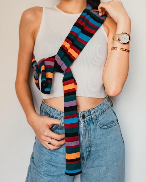 Image of a person's torso showing layered clothing with various accessories such as a belt, a scarf, and jewelry. The accessories are what brings the look together.