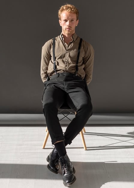 A person wearing an androgynous outfit featuring a crisp white button-down shirt, black skinny jeans, and Dr. Martens boots, accessorized with suspenders and a simple silver necklace.