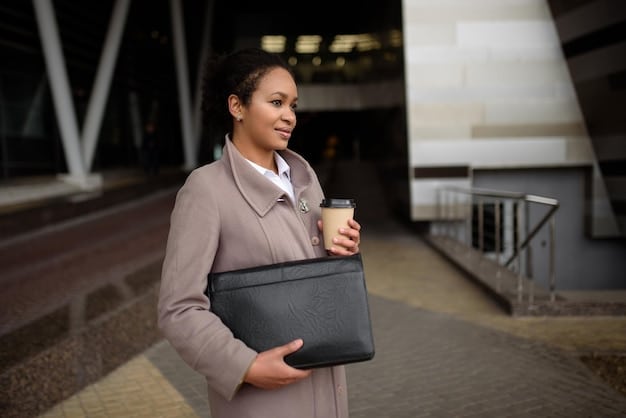 A person carrying a structured leather tote bag in a neutral color, paired with a minimalist outfit consisting of a tailored blazer and trousers. The background is a modern office setting.