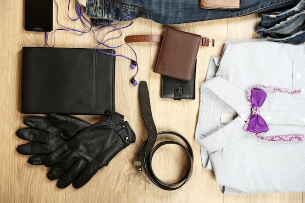 A close-up shot of various androgynous clothing items laid out on a table, including a black blazer, a white button-down shirt, dark-wash jeans, and a pair of chunky boots. The color scheme is primarily neutral.