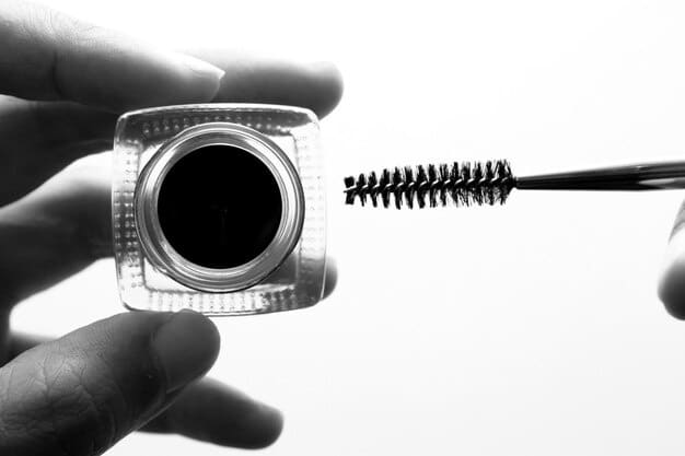 A close-up shot of a man applying a gel eyeliner with an angled brush, demonstrating focus and precision during the application process.