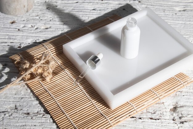 A clean, minimalistic bathroom counter with a gentle facial cleanser, a serum bottle, and a moisturizer tub, all labeled with ingredients suitable for oily skin. A soft towel is folded nearby.