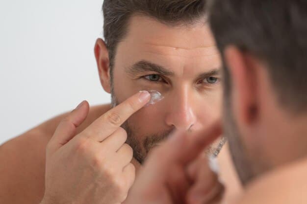 A man gently applying a small amount of eye cream with his ring finger around his under-eye area, demonstrating proper technique.