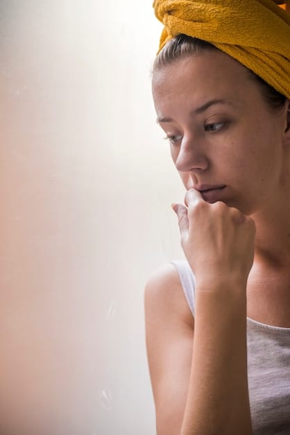 A close-up of a woman using a gentle foam cleanser on her face after a workout, with steam visible in the background, suggesting a shower environment.