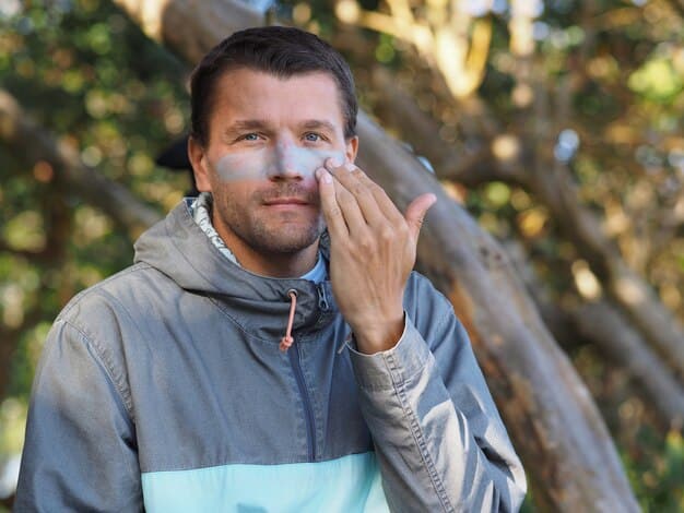 A man outdoors, potentially hiking or by a window, applying sunscreen to his face. Natural lighting, emphasizing healthy skin protection.