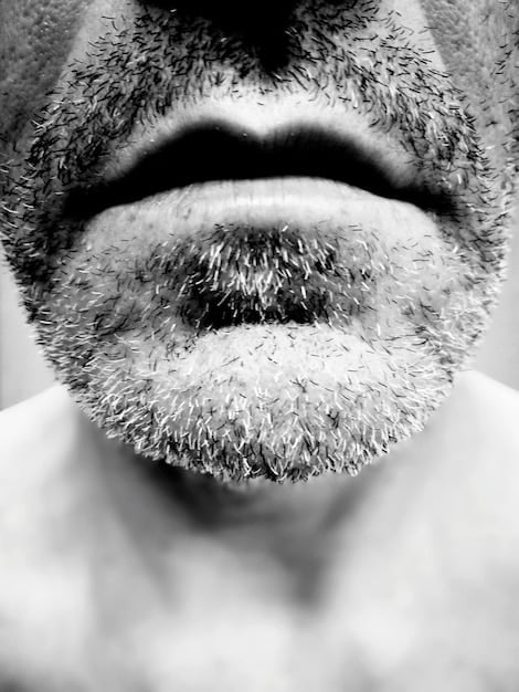 A close-up of a well-groomed American man with a classic chevron mustache, his expression confident and the lines of his facial hair sharp.