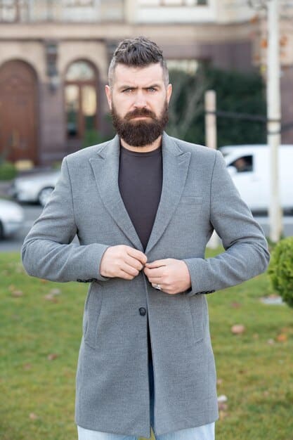A confident man in a business casual setting, his face clearly visible, with well-shaped, thick eyebrows that add to his authoritative and charismatic presence. The image conveys professionalism and subtle style.