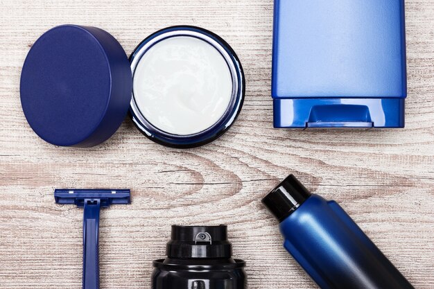A detailed flat lay of various men's hair styling products – a pomade jar, a clay tub, and a hairspray can – artfully arranged on a minimalist background, emphasizing their packaging and professional aesthetic.