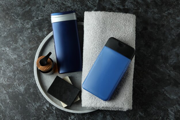 A clean, minimalist flat lay of men's grooming products: a bottle of cleanser, a moisturizer, and a face mask in a modern bathroom setting, emphasizing integration into a routine.