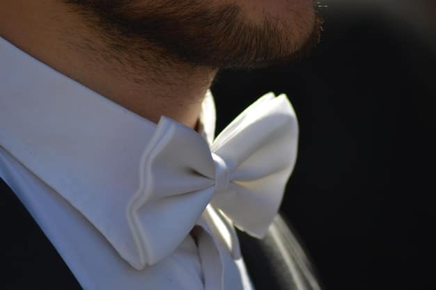 A detailed close-up of a man's tuxedo, highlighting the satin lapels, bow tie, and crisp white shirt. The focus is on the texture and quality of the fabric. This image visually represents the elegance required in Decoding Dress Codes: A Man's Guide to Navigating Any Occasion in 2025 for formal events.