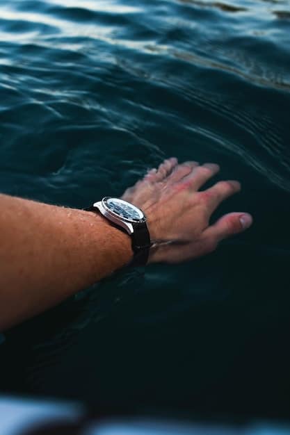 A professional lifestyle shot of a man's wrist underwater wearing a dive watch with a luminous dial, a black rubber strap, and a stainless steel case. The surrounding water is clear and blue, with sunlight filtering through, illuminating the watch and creating a dynamic underwater scene. The image represents the robustness and clarity of dive watches, as covered in The Ultimate Guide to Men's Watch Styles: Finding Your Perfect Timepiece in 2025.