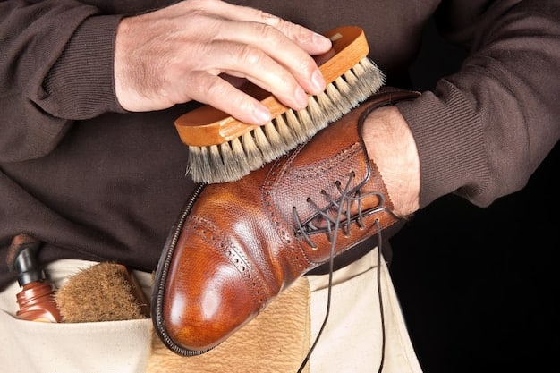 A man diligently cleaning his leather shoes with a brush and polishing cloth. The close-up shot focuses on the tools and the shoe, highlighting the care and attention to detail required to maintain high-quality footwear.
