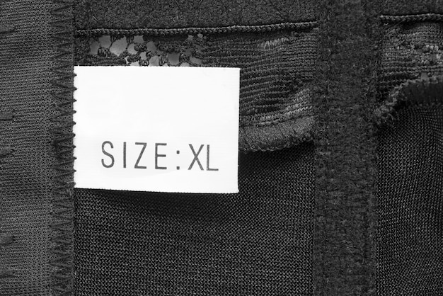 A close-up shot of a men's clothing size tag, highlighting the different sizing systems (e.g., US, EU, UK). The tag also includes details about the fabric composition and care instructions. The image emphasizes the importance of paying attention to these details when determining How to Find the Perfect Fit: A Guide to Men's Clothing Sizes in 2025.