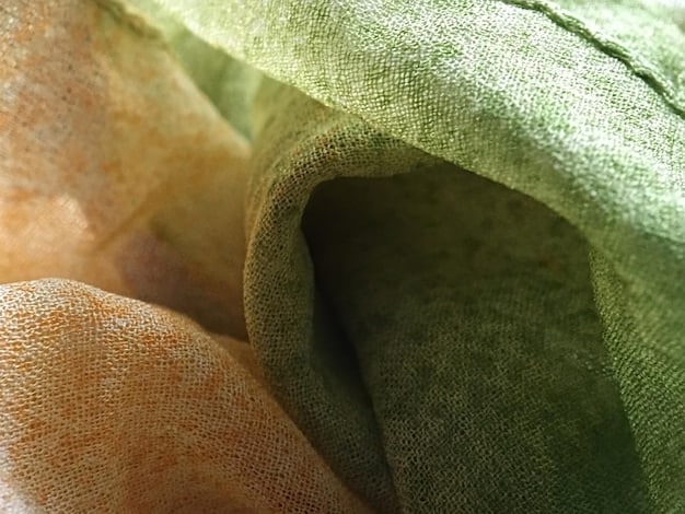 A close-up shot of various eco-friendly fabrics, such as organic cotton, hemp, and recycled polyester. The textures of the fabrics are clearly visible, emphasizing the natural and sustainable aspect of the materials used in creating a Sustainable Style: Building an Eco-Friendly Men's Wardrobe in 2025.