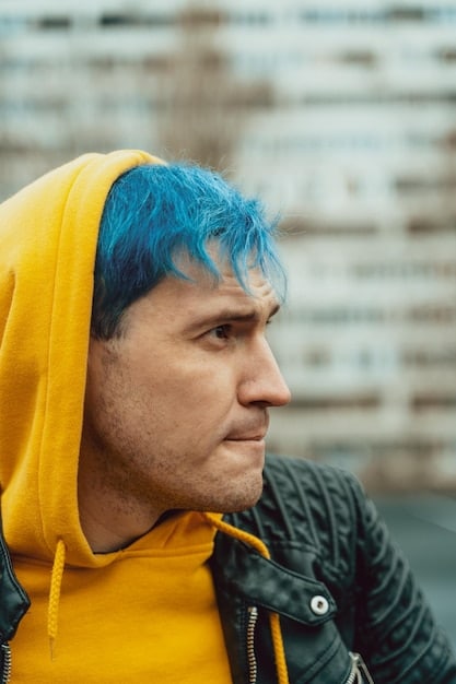 A man with half of his hair dyed a vibrant brown and the other half his original gray, highlighting the before-and-after contrast achieved with the men's hair dye, demonstrating the immediate color impact from our testing process: 'We Tried the Top-Rated Men's Hair Dyes of 2025: See Which One Lasted Over 6 Weeks'.