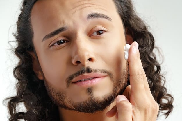 A close-up of a man applying a subtle tinted moisturizer to his cheek with a dense, flat-top foundation brush, demonstrating precise and seamless blending, with a focus on the brush's bristles and the natural skin texture.